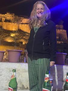 a woman standing next to three bottles of soda at Mirvana Guest House & Camel safari in Jaisalmer