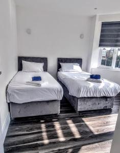 2 camas individuales en un dormitorio con 2 ventanas en Star London Finchley Lane 3-Bed Residence with Garden, en Hendon