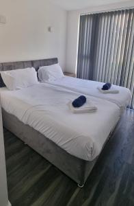 a bed with two hats and towels on it at Star London Finchley Lane 3-Bed Residence with Garden in Hendon