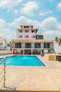 een villa met een zwembad voor een gebouw bij Hotel Caribe Coveñas in Coveñas