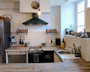 a kitchen with a sink and a stove at Le Clos Baroussais in Thèbe