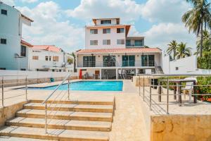 een villa met een zwembad en een trap bij Hotel Caribe Coveñas in Coveñas