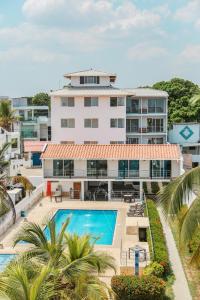 een uitzicht op een gebouw met een zwembad en palmbomen bij Hotel Caribe Coveñas in Coveñas