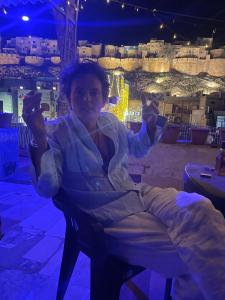 a woman sitting in a chair in a room with a view at Mirvana Guest House & Camel safari in Jaisalmer