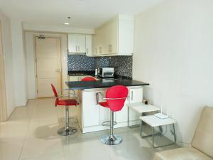 a kitchen with two red chairs and a counter at Minimalist Condotel at SMDC Sea Residences in Manila