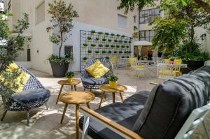 een gemeubileerde patio met tafels en stoelen bij Dizengoff square boutique in Tel Aviv