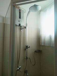 a shower in a bathroom with a shower head at Minimalist Condotel at SMDC Sea Residences in Manila