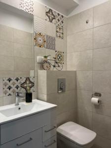La salle de bains est pourvue d'un lavabo blanc et de toilettes. dans l'établissement Apartament Chiara, à Oleśnica