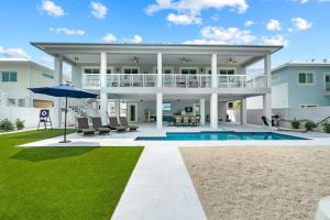 a villa with a swimming pool and a house at Luna Light ~ Waterfront ~ Pool ~ Dock ~ Views in Marathon