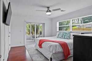 a white bedroom with a bed and a window at Oasis: Hot tub, fire pit, fun! in Vero Beach