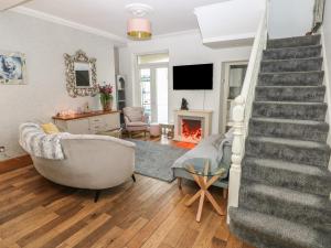 a living room with a staircase and a fireplace at 5 Pontardulais Road in Llanelli