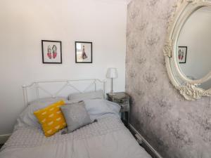 een slaapkamer met een bed met een spiegel aan de muur bij 5 Pontardulais Road in Llanelli