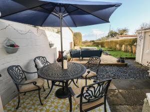 een tafel en stoelen met een parasol op een patio bij 5 Pontardulais Road in Llanelli