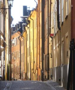 een steegje met gele gebouwen in een stadsstraat bij Executive Living Old Town Unique in Stockholm