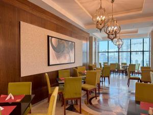 麥加的住宿－فندق الصفوة البرج الأول 1 Al Safwah Hotel First Tower，一间带桌椅的用餐室和一幅画