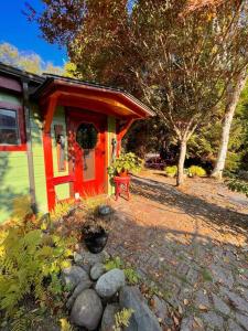 a small house with a red bench in front of it at Nostalgic Downtown Boatbuilder's Cabin - Licensed in Squamish