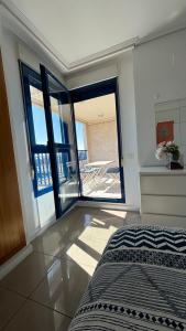 a bedroom with a bed and a balcony with a table at Apto. luminoso con vistas en playa de La Patacona in Valencia