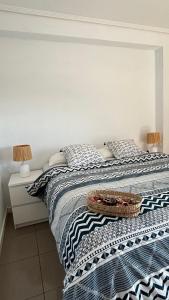 a bed with a black and white blanket and two lamps at Apto. luminoso con vistas en playa de La Patacona in Valencia