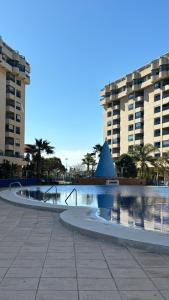 a swimming pool in front of two tall buildings at Apto. luminoso con vistas en playa de La Patacona in Valencia