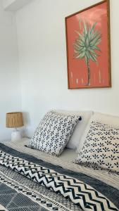 1 cama con 2 almohadas y una foto en la pared en Apto. luminoso con vistas en playa de La Patacona en Valencia