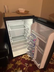 - un réfrigérateur vide avec une porte ouverte avec des bouteilles d'eau dans l'établissement Cute 2 beds room , for females only, à Ottawa