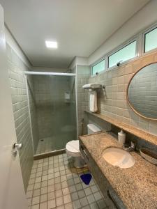 uma casa de banho com um chuveiro, um lavatório e um WC. em Ancorar Flat Resort em Porto de Galinhas