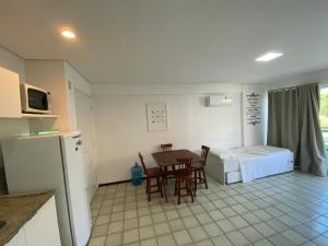 uma cozinha com uma mesa e cadeiras e uma cama em Ancorar Flat Resort em Porto de Galinhas