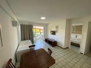 um quarto com uma mesa e uma cama e um quarto em Ancorar Flat Resort em Porto de Galinhas