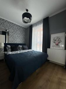 um quarto com uma cama azul e uma janela em Apartament Szarotki em Szczecin