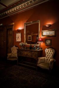 a room with a mirror and a desk and chairs at The Alamo Guest House in Glasgow