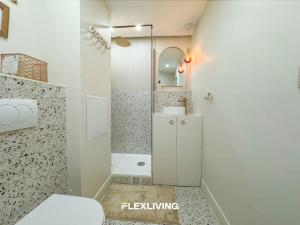 La salle de bains blanche est pourvue d'une douche et de toilettes. dans l'établissement Luxury Studio in city center, à Paris