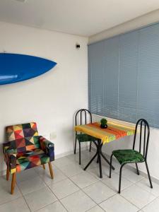 a dining room with a table and two chairs at Quarto e sala pé na areia in Guarapari
