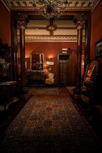 a hallway with a living room with a large rug at The Alamo Guest House in Glasgow