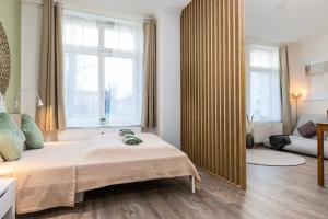 ein Schlafzimmer mit einem Bett und einem großen Fenster in der Unterkunft Modern, gemütlich, zentral & nahe KarLi in Leipzig