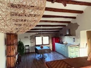 a living room with a table and a kitchen at Cal Muntanyès in Font-Rubí