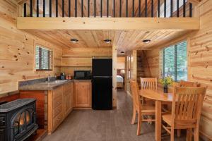 una cocina con nevera y una mesa en una cabaña en El Capitan Canyon, en Capitan