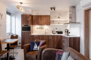 a kitchen with wooden cabinets and a living room at Poppies Flats in Ieper
