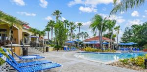 - une piscine avec des chaises longues bleues et des palmiers dans l'établissement 201 Hideaway beach 4 beds - pool&spa, à Kissimmee