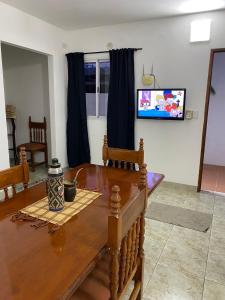 a living room with a wooden table and a tv at Sarmiento 595 in Paso de los Libres