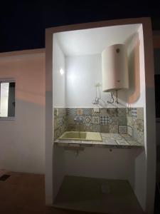 a bathroom with a sink and a light on the wall at Sarmiento 595 in Paso de los Libres