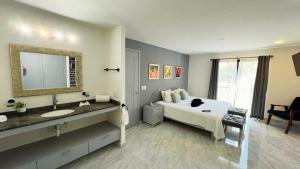 een slaapkamer met een bed, een wastafel en een spiegel bij Residences by MP Cabo San Lucas in Cabo San Lucas