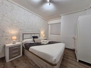 a bedroom with a large bed and a nightstand with two lamps at Feeling Home Catedral in León