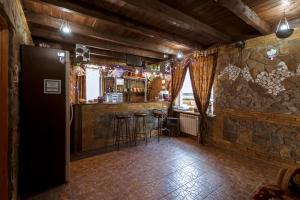 um bar com bancos numa sala com uma parede de pedra em Shato Leopard em Dombay
