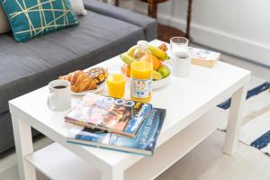 a white coffee table with fruit and drinks on it at Stylish Apartment Near Broadway Theatre in Catford