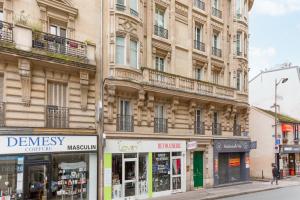巴黎的住宿－Le studio d'Alésia，城市街道上一座拥有商店的大建筑