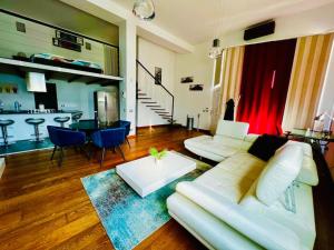 een woonkamer met een witte bank en een tafel bij Moderno loft alle porte di Milano - 115mq - 3 posti in Cormano
