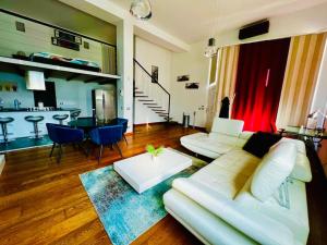 a living room with a white couch and a table at Moderno loft alle porte di Milano - 115mq - 3 posti in Cormano