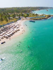 an aerial view of a beach with people and umbrellas at Palmarito Beach Hotel in Tierra Bomba