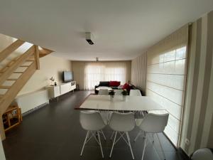 a living room with a white table and chairs at Vakantiehuis De Panne in De Panne