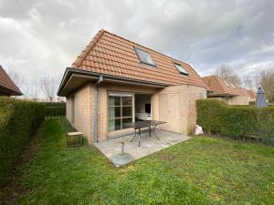a house with a picnic table in the yard at Vakantiehuis De Panne in De Panne